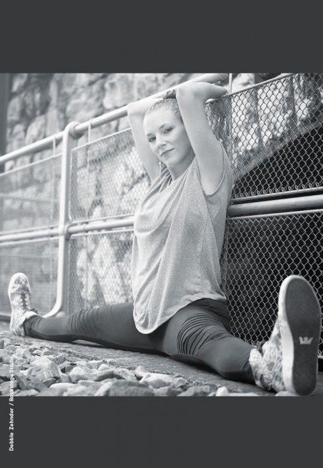 Backstage Studio: Debbie Zehnder doing a split, sitting and leaning against a fence